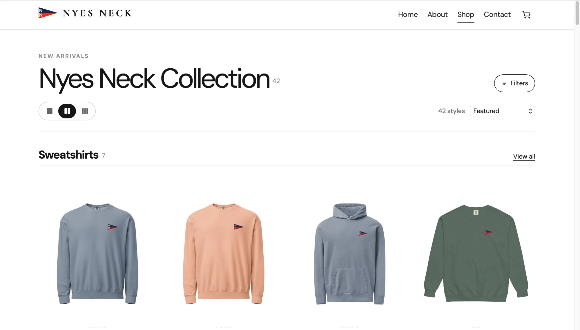 The Nyes Neck shop page: the “Nyes Neck Collection” heading with 42 styles, grid-density and sort controls, and a Sweatshirts row of three crewnecks and a hoodie, each embroidered with the small red, white and navy pennant logo.